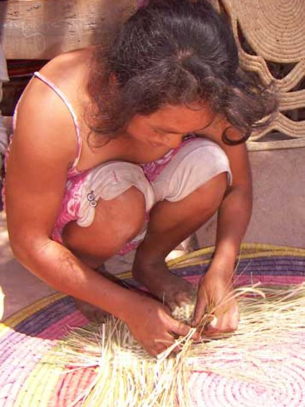 9. ”Rariboka” är en flätteknik där haravolagräset kombineras med soltorkade raffiapalmblad.  Här en av kvinnorna i byn som behärskar tekniken. 